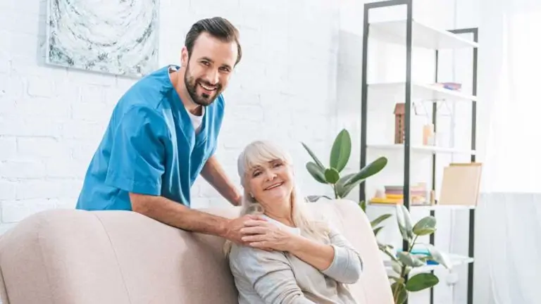 happy senior woman and young social worker smiling at camera together